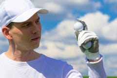 Gloved hand holding a golf ball stock photo Gloved hand holding a golf ball stock photo