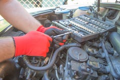 Gloved Hands Of A Mechanic Working On A Car Engine As He Services Or Repairs It In A Workshop Or Garage Royalty Free Stock Photos