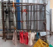 Gloves and Umbrellas for Fisherman hanging by mesh on wall royalty free stock photo Gloves and Umbrellas for Fisherman hanging by mesh on wall royalty free stock photo
