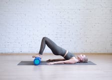 Gluteal brug op schuimrol Jonge Kaukasische vrouw die pilates met speciaal materiaal in geschiktheidsstudio doen stock afbeeldingen Gluteal brug op schuimrol Jonge Kaukasische vrouw die pilates met speciaal materiaal in geschiktheidsstudio doen stock afbeeldingen