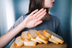 Glutenintoleranzkonzept Junges Mädchen lehnt ab, weißes brea zu essen stockfotografie Glutenintoleranzkonzept Junges Mädchen lehnt ab, weißes brea zu essen stockfotografie