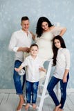 Glückliche Familie mit schwangerer Frau und den Kindern, die im Studio aufwerfen stockfotos Glückliche Familie mit schwangerer Frau und den Kindern, die im Studio aufwerfen stockfotos