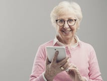 Glückliche ältere Dame unter Verwendung einer digitalen Tablette stockbild Glückliche ältere Dame unter Verwendung einer digitalen Tablette stockbild