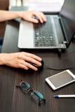 Gläser und Smartphone auf dem Tisch, Laptop mit den menschlichen Händen auf einem Hintergrund lizenzfreies stockfoto Gläser und Smartphone auf dem Tisch, Laptop mit den menschlichen Händen auf einem Hintergrund lizenzfreies stockfoto