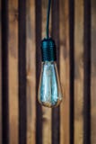 Glödande lampa på träbakgrund arkivfoton Glödande lampa på träbakgrund arkivfoton