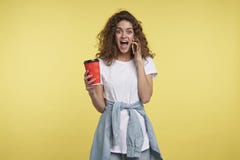 Glücklich und von der Telefonanruf Brunettefrau mit gelocktem überrascht, ein Kaffeetassehaar halten, Atelieraufnahme lokalisiert stockfotos Glücklich und von der Telefonanruf Brunettefrau mit gelocktem überrascht, ein Kaffeetassehaar halten, Atelieraufnahme lokalisiert stockfotos