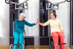Glückliche alte Frauen an der Turnhalle, die durch Palmen sich berührt stockfoto Glückliche alte Frauen an der Turnhalle, die durch Palmen sich berührt stockfoto