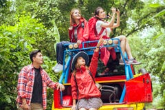 Glückliche asiatische junge Reisende mit 4WD fahren Auto weg von der Straße im Wald lizenzfreies stockbild Glückliche asiatische junge Reisende mit 4WD fahren Auto weg von der Straße im Wald lizenzfreies stockbild
