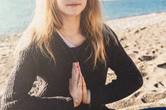 Glückliche entspannte junge Frau, die in einer Yogahaltung am Strand meditiert lizenzfreies stockfoto Glückliche entspannte junge Frau, die in einer Yogahaltung am Strand meditiert lizenzfreies stockfoto