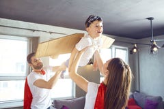 Glückliche Familie in den Superheldkostümen, die zusammen spielen stockfotografie Glückliche Familie in den Superheldkostümen, die zusammen spielen stockfotografie