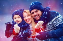 Glückliche Familie, die Spaß unter Schnee während der Winterurlaube hat Stockfoto Glückliche Familie, die Spaß unter Schnee während der Winterurlaube hat Stockfoto