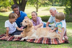 Glückliche Familie im Park mit ihrem Hund lizenzfreies stockbild Glückliche Familie im Park mit ihrem Hund lizenzfreies stockbild