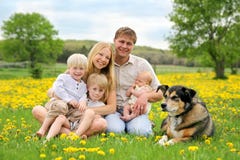 Glückliche Familie und Schoßhund in der Blumen-Wiese stockbilder Glückliche Familie und Schoßhund in der Blumen-Wiese stockbilder