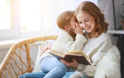 Glückliche Familienmutter liest Buch zum Kind zur Tochter durch Fenster lizenzfreies stockfoto Glückliche Familienmutter liest Buch zum Kind zur Tochter durch Fenster lizenzfreies stockfoto