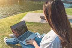 Glückliche Frau, die Laptop im Park, absichtlich getont verwendet stockbild Glückliche Frau, die Laptop im Park, absichtlich getont verwendet stockbild