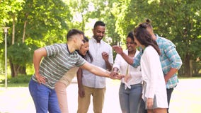 Glückliche Freunde, die Hände im Park stapeln stock video footage Glückliche Freunde, die Hände im Park stapeln stock video footage