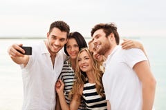 Glückliche Freunde, die selfie auf Sommerstrand nehmen lizenzfreie stockbilder Glückliche Freunde, die selfie auf Sommerstrand nehmen lizenzfreie stockbilder