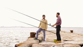 Glückliche Freunde mit Angeln auf Pier stock video footage Glückliche Freunde mit Angeln auf Pier stock video footage