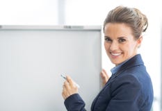 Glückliche Geschäftsfrau nahe flipchart lizenzfreies stockbild Glückliche Geschäftsfrau nahe flipchart lizenzfreies stockbild