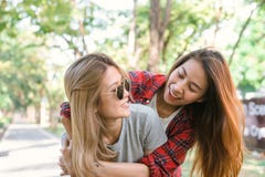 Glückliche junge asiatische Frauen verbinden miteinander spielen, während sie Stadtreise im warmen Sonnenlichtmorgenwochenende tu Lizenzfreie Stockbilder Glückliche junge asiatische Frauen verbinden miteinander spielen, während sie Stadtreise im warmen Sonnenlichtmorgenwochenende tu Lizenzfreie Stockbilder