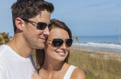 Glückliche Mann-Frauen-Paare in der Sonnenbrille am Strand Stockfoto Glückliche Mann-Frauen-Paare in der Sonnenbrille am Strand Stockfoto