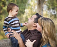 Glückliche Mischrennen-ethnische Familie, die im Park spielt lizenzfreie stockfotos Glückliche Mischrennen-ethnische Familie, die im Park spielt lizenzfreie stockfotos