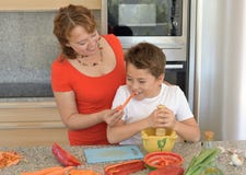 Glückliche Mutter und Sohn, die das Mittagessen mit einem Mörser vorbereitet stockfotos Glückliche Mutter und Sohn, die das Mittagessen mit einem Mörser vorbereitet stockfotos