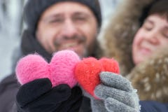 Glückliche Paare von mittlerem Alter, die draußen in den Händen zwei woolen Herzen halten lizenzfreies stockbild Glückliche Paare von mittlerem Alter, die draußen in den Händen zwei woolen Herzen halten lizenzfreies stockbild