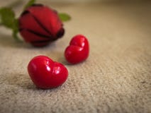 Glückliche stiegen rote Herzen des Valentinstags zwei und auf den hellbraunen Teppich Lizenzfreies Stockbild Glückliche stiegen rote Herzen des Valentinstags zwei und auf den hellbraunen Teppich Lizenzfreies Stockbild