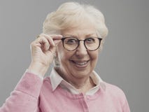 Glückliche ältere Dame, die ihre Gläser aufwirft und zeigt stockfoto Glückliche ältere Dame, die ihre Gläser aufwirft und zeigt stockfoto