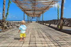 Glücklicher Babyweg durch hölzerne Brücke zum Ozeanstrand stockfoto Glücklicher Babyweg durch hölzerne Brücke zum Ozeanstrand stockfoto