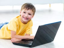 Glücklicher Junge mit Laptop Lizenzfreie Stockfotografie Glücklicher Junge mit Laptop Lizenzfreie Stockfotografie