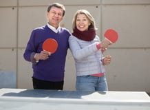Glücklicher reifer Mann und eine Frau, die Tischtennis spielt lizenzfreie stockfotos Glücklicher reifer Mann und eine Frau, die Tischtennis spielt lizenzfreie stockfotos