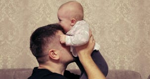 Glücklicher Vati spielt mit seinem unglaublich netten und lachenden Baby stock video footage Glücklicher Vati spielt mit seinem unglaublich netten und lachenden Baby stock video footage