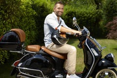 Glücklicher zufälliger Mann, der schwarzen Roller reitet stockbild Glücklicher zufälliger Mann, der schwarzen Roller reitet stockbild
