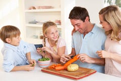 Glückliches Familienschalengemüse in der Küche stockbild Glückliches Familienschalengemüse in der Küche stockbild