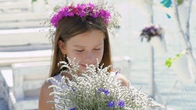 Glückliches intelligentes Mädchen, das mit Blumen und dem Lächeln bewundert langsam stock footage Glückliches intelligentes Mädchen, das mit Blumen und dem Lächeln bewundert langsam stock footage