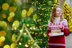 Glückliches junges Mädchen in der Feiertagsstrickjacke mit Stapel von Weihnachtsgeschenken stockfoto Glückliches junges Mädchen in der Feiertagsstrickjacke mit Stapel von Weihnachtsgeschenken stockfoto