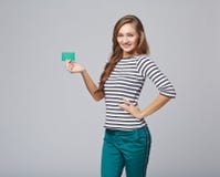 Glückliches lächelndes Mädchen in der Freizeitbekleidung, leere Kreditkarte zeigend stockfotografie Glückliches lächelndes Mädchen in der Freizeitbekleidung, leere Kreditkarte zeigend stockfotografie