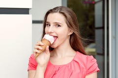 Glückliches Mädchen, das draußen Eiscreme nahe Speicher isst stockfotografie Glückliches Mädchen, das draußen Eiscreme nahe Speicher isst stockfotografie