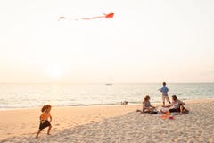 Glückliches Mädchen und Familie auf Sonnenuntergangstrand stockbild Glückliches Mädchen und Familie auf Sonnenuntergangstrand stockbild