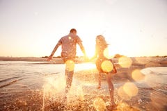 Paare, die auf den Strand laufen lizenzfreies stockfoto Paare, die auf den Strand laufen lizenzfreies stockfoto