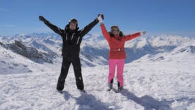 Glückliches Skifahrerpaar steht auf der Bergspitze und steigt ihre Hände stockfoto Glückliches Skifahrerpaar steht auf der Bergspitze und steigt ihre Hände stockfoto