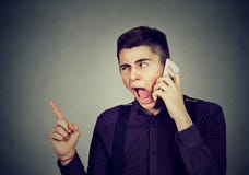 Gniewny młody człowiek krzyczy na telefonie komórkowym zdjęcia royalty free Gniewny młody człowiek krzyczy na telefonie komórkowym zdjęcia royalty free