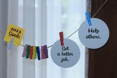 2021 Goals - Get a better job. Help others. New Year resolution concept with paper label notes sign hanging on a rope.