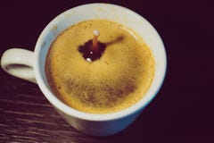 Goccia del latte che cade in una tazza di caffè immagini stock libere da diritti Goccia del latte che cade in una tazza di caffè immagini stock libere da diritti