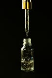 Luxurious facial serum container with dropper on black background royalty free stock photography Luxurious facial serum container with dropper on black background royalty free stock photography