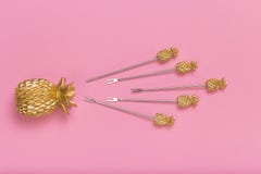 Golden pineapple caps on a pink background stock photo Golden pineapple caps on a pink background stock photo
