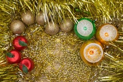 Golden, red, green and yellow New Year or Christmas baubles on golden base with golden ragged decoration. royalty free stock photography Golden, red, green and yellow New Year or Christmas baubles on golden base with golden ragged decoration. royalty free stock photography