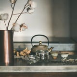 Golden teapot and cups on concrete counter, square crop royalty free stock image Golden teapot and cups on concrete counter, square crop royalty free stock image